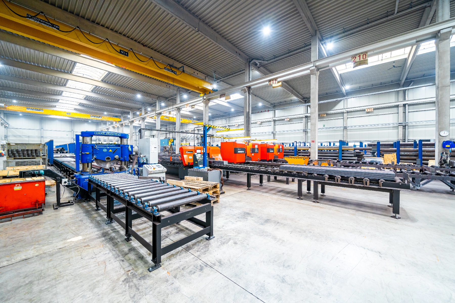 Produktionshalle der QSZ Group – CNC-Maschinen und Facharbeiter bei der Metallbearbeitung